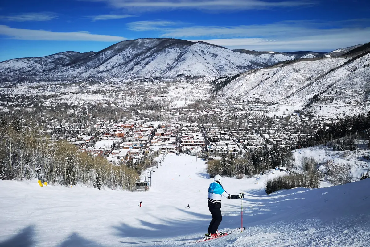Skier above Aspen with the town in the valley below